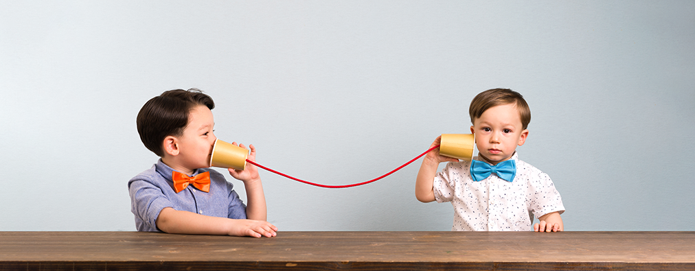 young boys communicating with cups and string